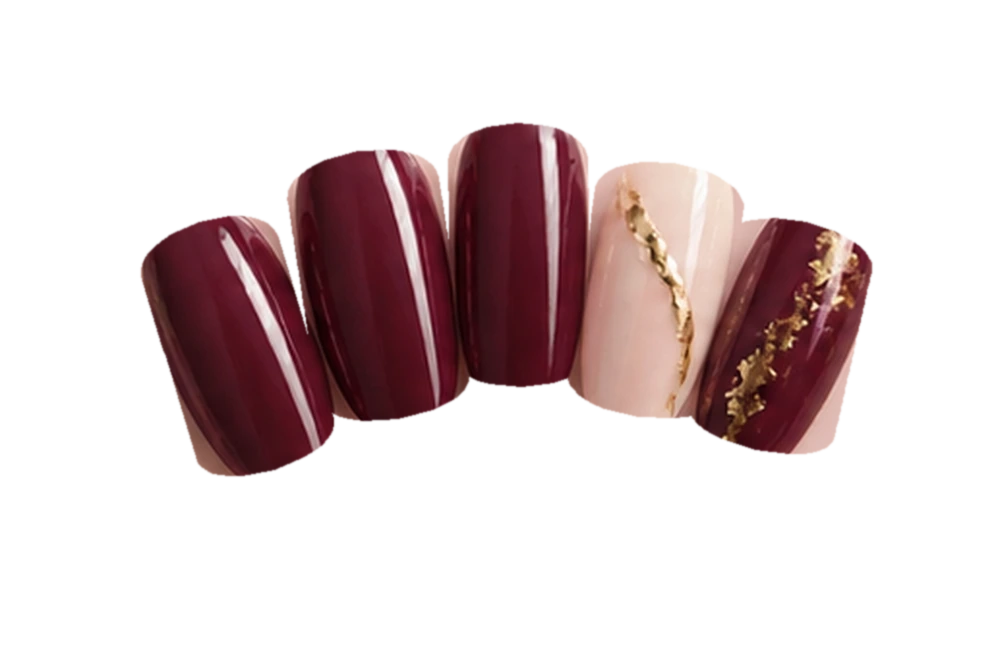 Burgundy five-nail manicure with ivory accent nail, gold leaf and glossy finishes